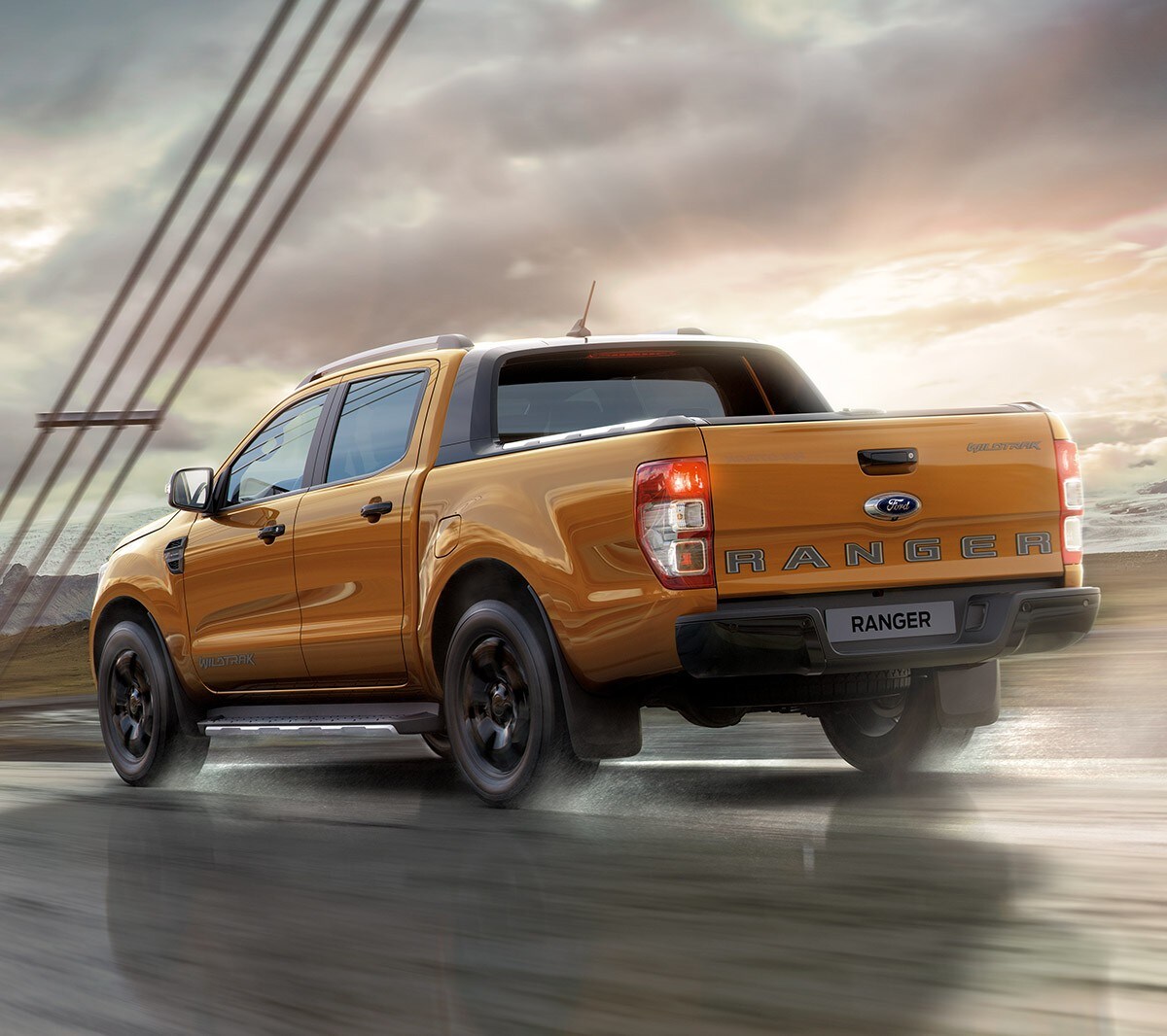 Oranje Ford Ranger Wildtrak op de snelweg, achteraanzicht