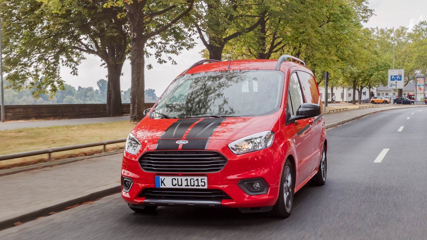 Rode Ford Transit Courier rijdt op de weg