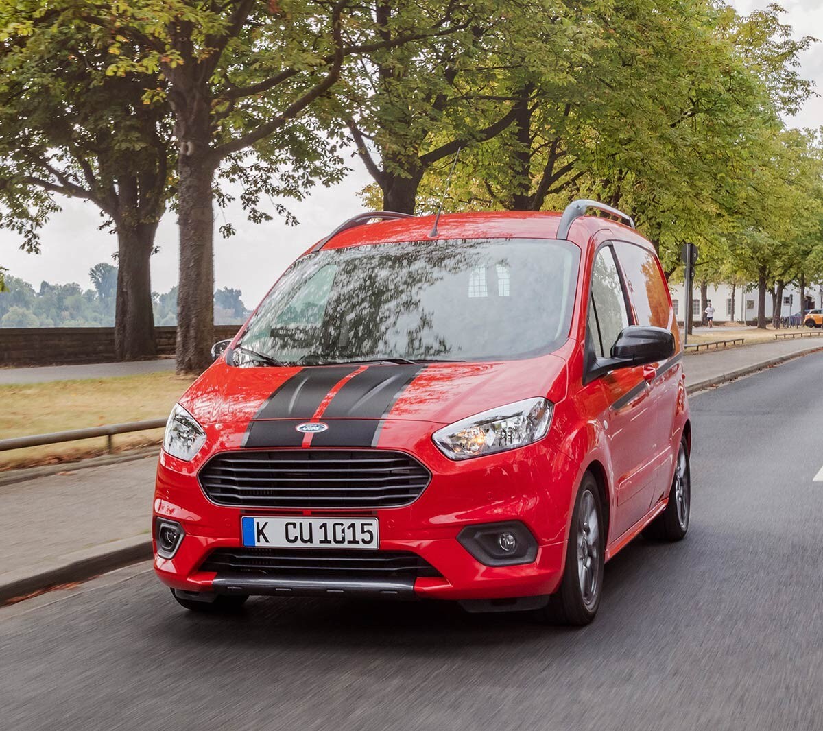 Rode Ford Transit Courier rijdt op de weg