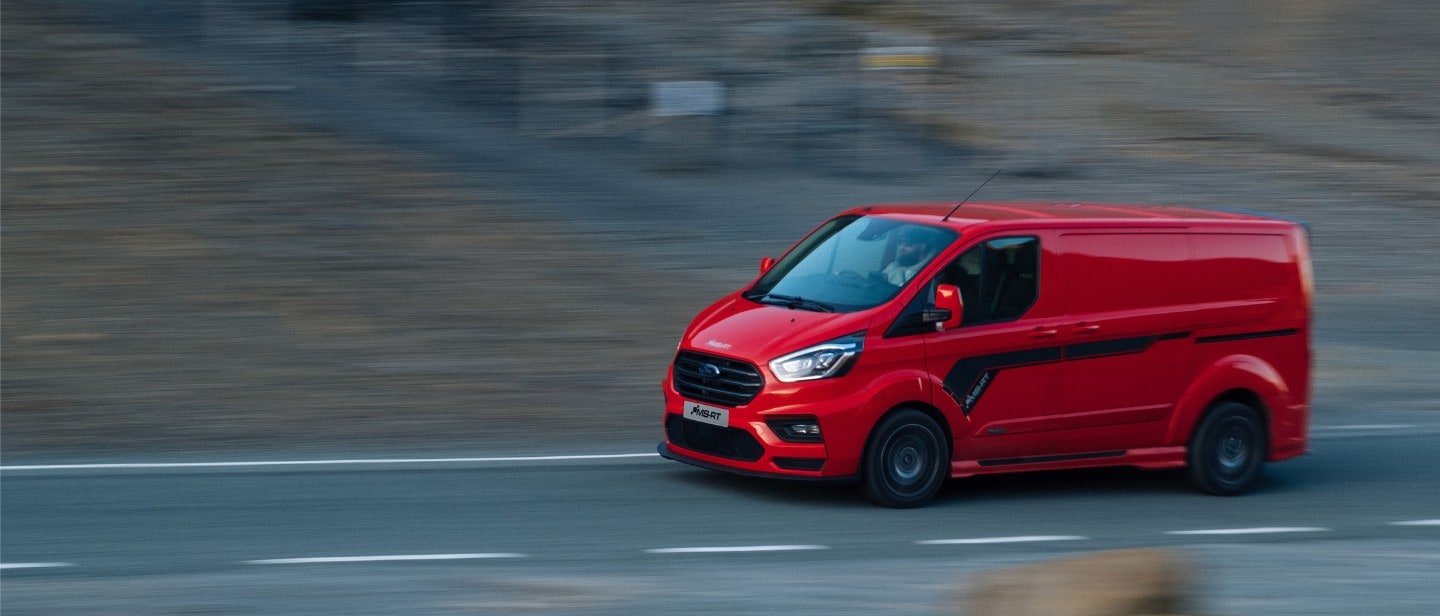 Red Ford Transit Custom MS-RT driving past a hill