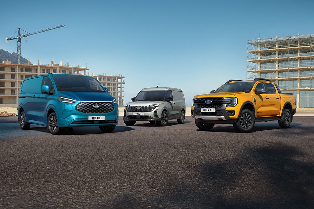 Een verzameling Ford-voertuigen geparkeerd voor een bouwplaats.