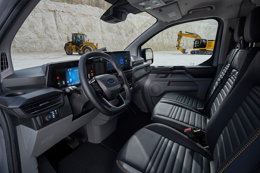 Binnenaanzicht van een Ford Transit Custom-bestelwagen, met het dashboard, het stuur en de stoelen.