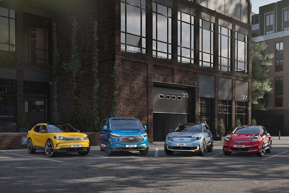 Een klein wagenpark van kleurrijke Ford-voertuigen staat geparkeerd in een moderne omgeving.