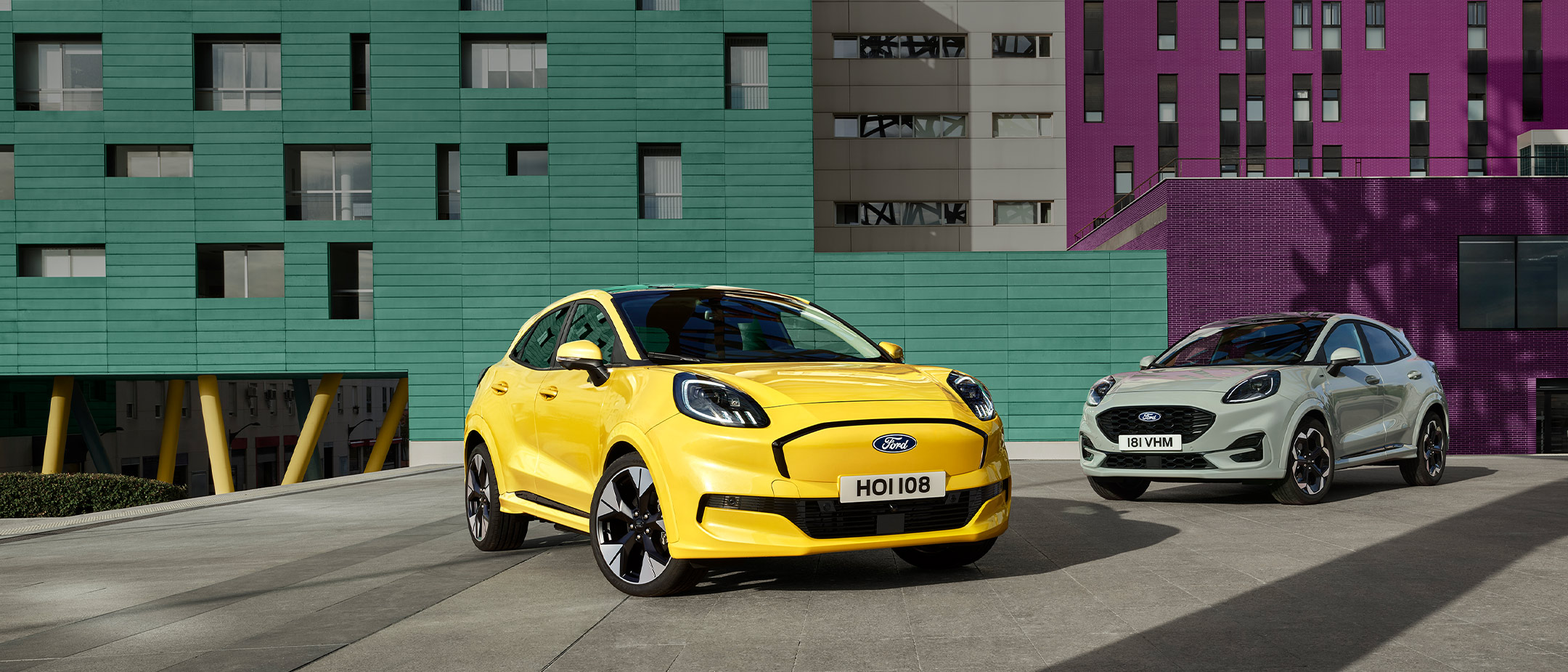Een gele elektrische Ford Puma Gen-E® geparkeerd naast een grijze EcoBoost® Ford Puma® op benzine. 