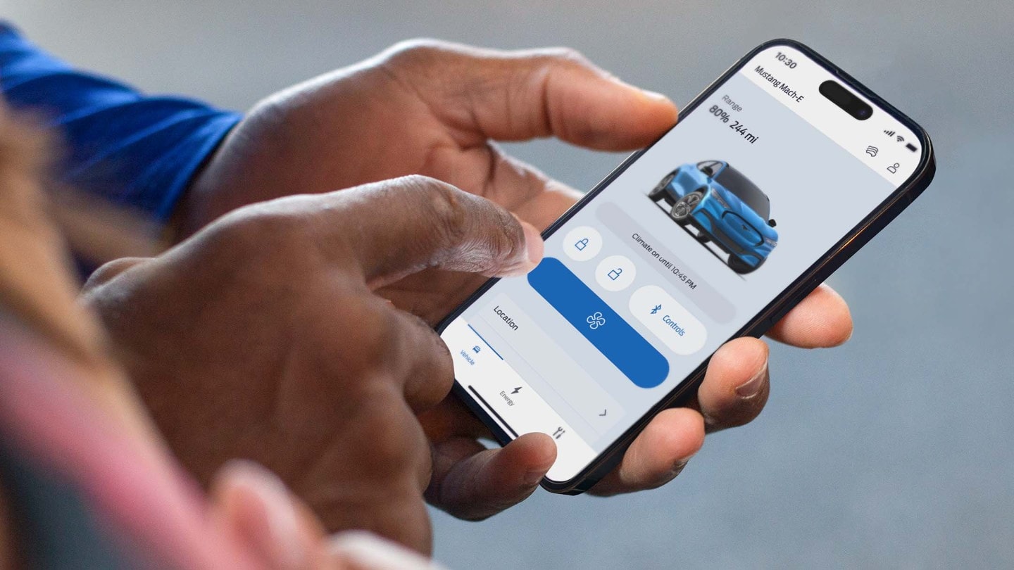 Man holding a phone using remote locking on the FordPass App
