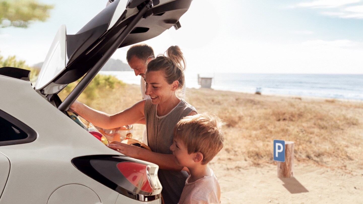 A family at the beach, loading items into the boot loadspace of a Ford vehicle