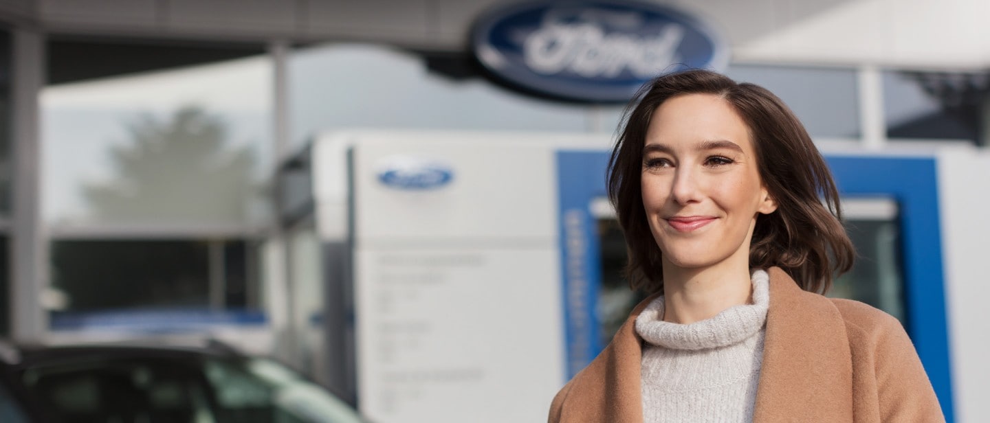 Smiling woman leaving the Ford Service