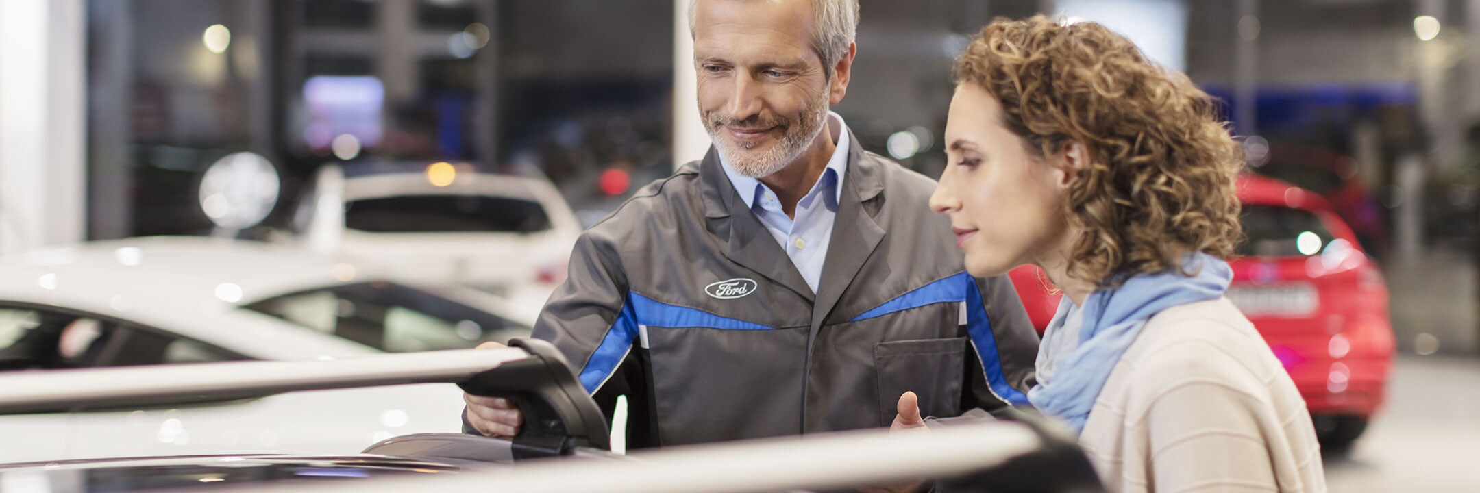 Ford dealer helping customer on car showroom